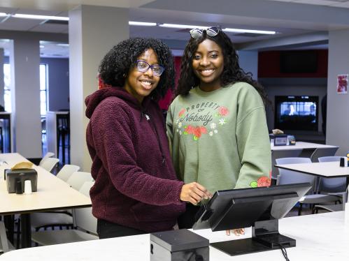 Two students interact with a device