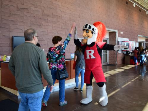 A student high-fives the Rutgers Scarlet Knight mascot